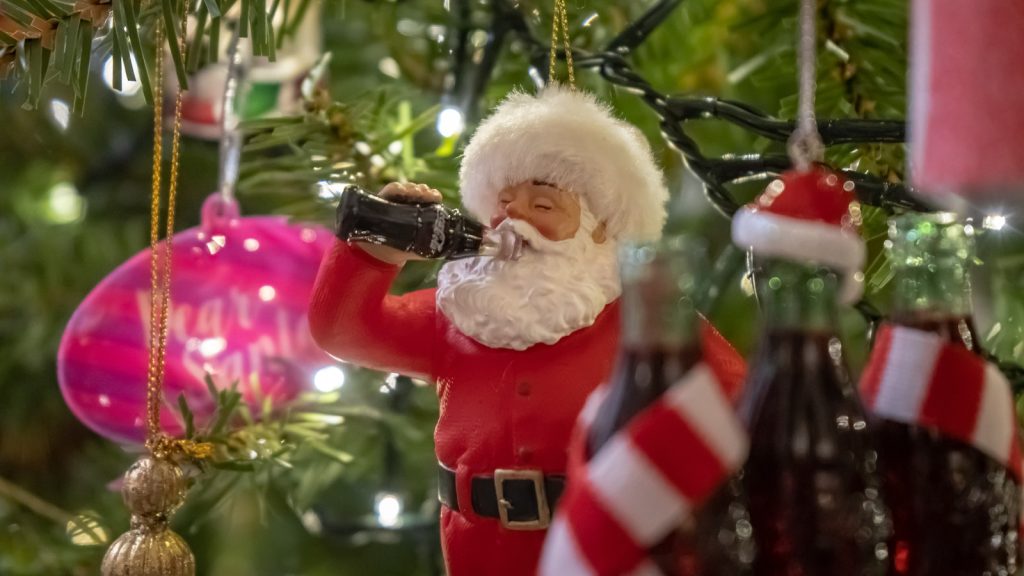 Santa drinking soda in a christmas tree